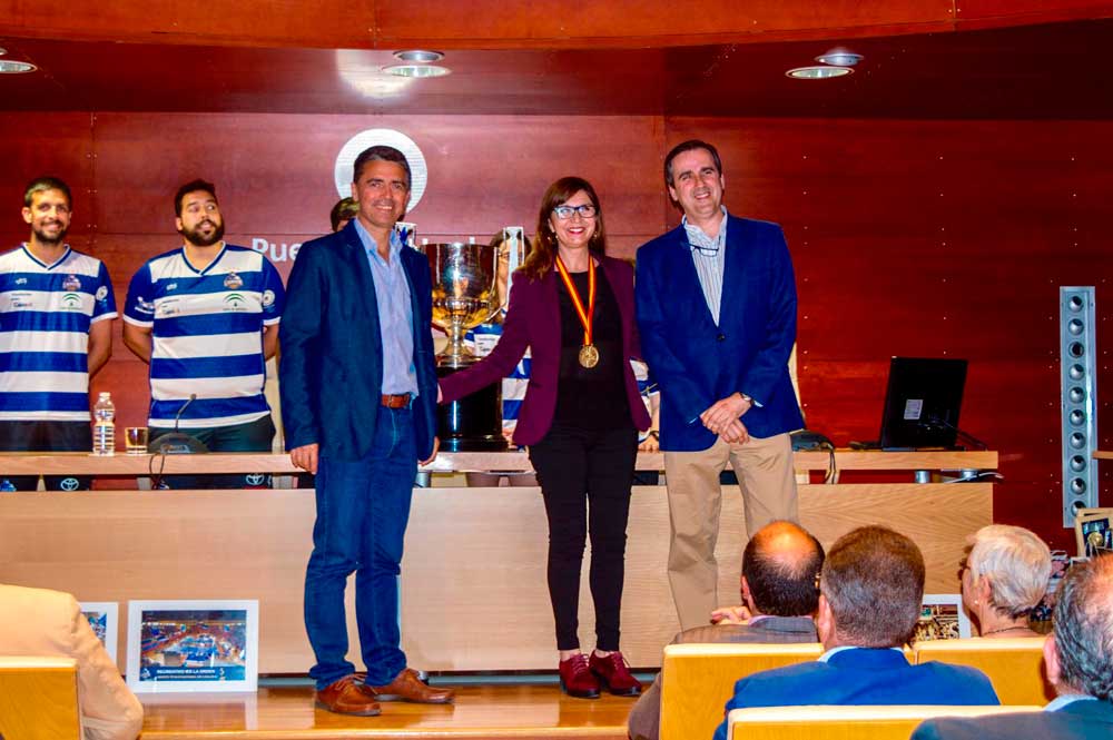 Matilde Valdivia, delegada de la Fundación Cajasol en Huelva, recibe la medalla por parte del Bádminton IES La Orden