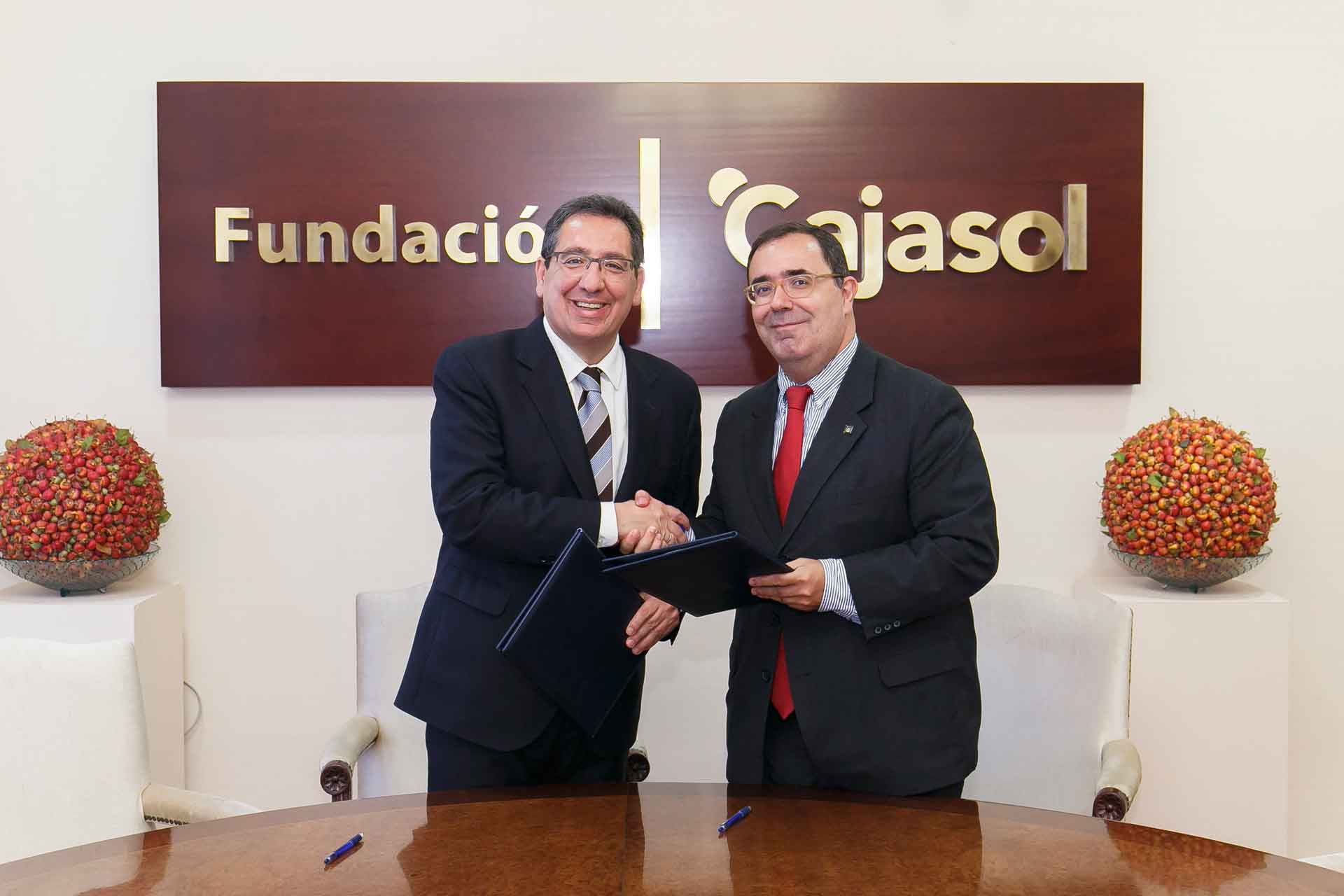 Antonio Pulido, presidente de la Fundación Cajasol, y Vicente Guzmán, rector de la UPO, sellando el acuerdo entre ambas entidades