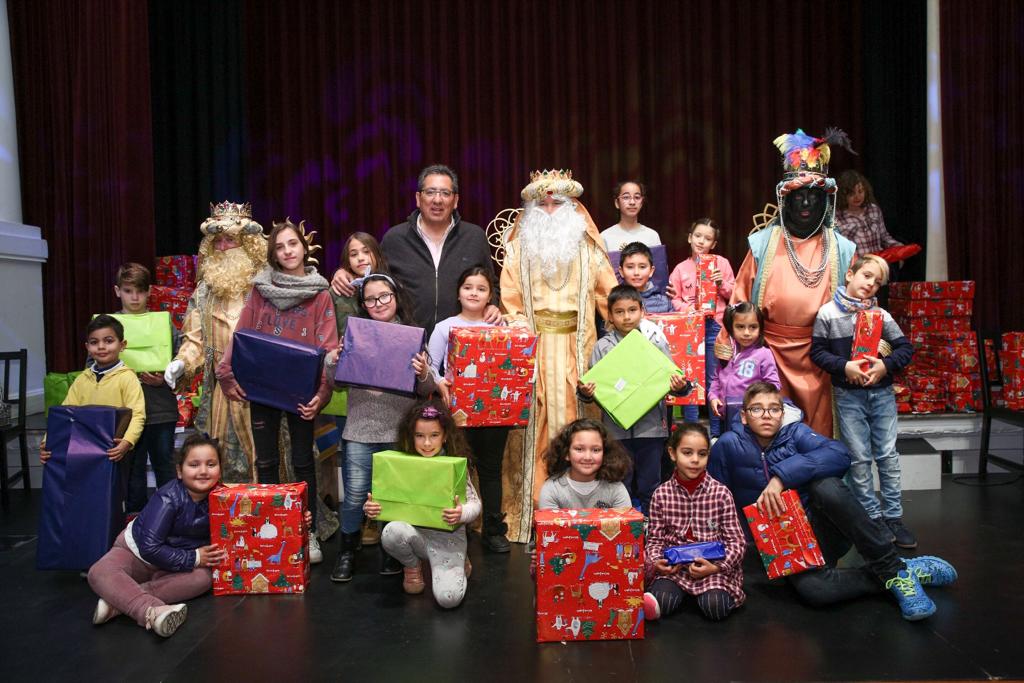 Antonio Pulido, presidente de la Fundación Cajasol, junto a los Reyes Magos y un grupo de niños con sus respectivos juguetes